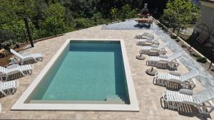 a group of chairs and a swimming pool with chairs and tables at Apartments Natalija1 -Krk in Krk