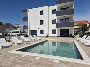 a swimming pool in front of a building at Apartments Natalija1 -Krk in Krk
