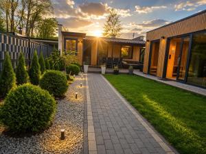 a backyard with a brick walkway in front of a house at APARTAMENT MIERZYN Sauna & Jacuzzi in Mierzyn