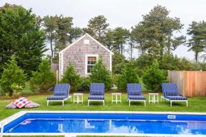 a group of three chairs and a swimming pool at Luxurious Nantucket Getaway Heated Pool in Nantucket