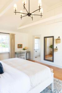 a bedroom with a white bed and a mirror at Luxurious Nantucket Getaway Heated Pool in Nantucket