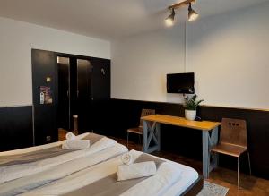 a room with two beds and a table and a television at Guest House Park Žibert in Ljubljana