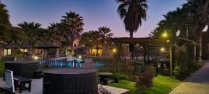 a patio with tables and umbrellas at night at Apart Hotel Gran Pacifico in La Serena