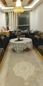 a living room with a table and a couch at Amir's home in Meknès