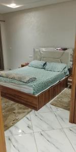 a bedroom with a bed in a room with marble floors at Amir's home in Meknès