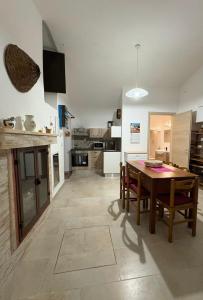 a kitchen and dining room with a table and chairs at Le Pozzelle Presicce, Bilocale Casa a Corte XVI sec in Presicce