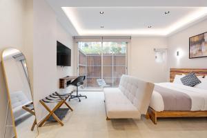 a bedroom with a bed and a chair and a desk at Guadalupe Inn in Mexico City