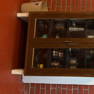 a wooden cabinet filled with bottles and cups at OceanBliss_Homestay04 in Villupuram