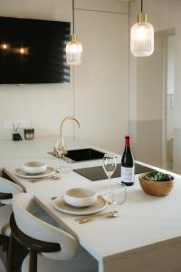 a kitchen with a table with plates and wine glasses at Suite Maiora - Élégance, Sérénité & Jacuzzi in Saumur +16 photos