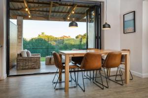 a dining room with a wooden table and chairs at Modern Coastal Retreat - Private Hot Tub & Sauna in Hermanus