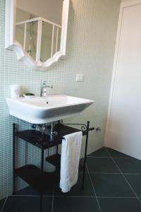 y baño con lavabo blanco y espejo. en Temporary Home Dragonara, en San Giovanni Teatino
