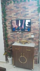 a tv mounted on a brick wall with a sink at casa martil 2 in Martil