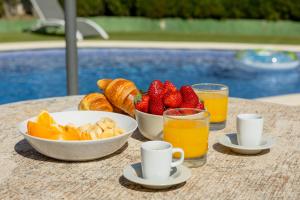 a table with a bowl of fruit and a bowl of orange juice at Casa L'Escala 30 in L'Escala