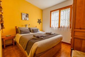 a bedroom with a large bed with yellow walls at Casa L'Escala 30 in L'Escala +6 photos