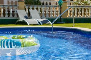 a swimming pool with a raft in the water at Casa L'Escala 30 in L'Escala
