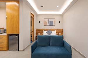 a room with a blue couch in front of a bed at Guadalupe Inn in Mexico City