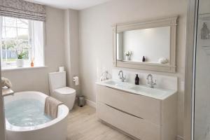 a bathroom with a tub and a sink and a toilet at Yarwell Mill in Nassington +44 photos