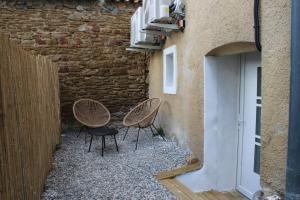 a couple of chairs sitting next to a building at "L'écrin d'amour" - Suite, Spa & Double pommeau in Ville-sous-Anjou