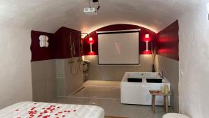 a bathroom with a sink and a shower with red lights at "L'écrin d'amour" - Suite, Spa & Double pommeau in Ville-sous-Anjou +5 photos