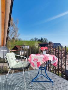 a table and two chairs on a patio with a table and flowers at Am Weiher mit Terrasse in Hergensweiler