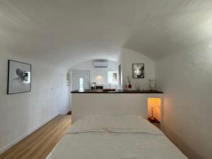 a white bedroom with a bed and a table at "L'écrin d'amour" - Suite, Spa & Double pommeau in Ville-sous-Anjou
