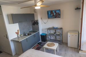 a small kitchen with a sink and a table at Escapade Marine - Vue Etang - Place de parking privé - Plage à 5 min in Le Barcarès +22 photos