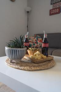 a table with a tray of food and two bottles of soda at Escapade Marine - Vue Etang - Place de parking privé - Plage à 5 min in Le Barcarès