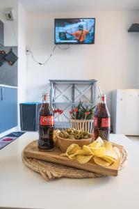 a table with two bottles of soda and a bowl of food at Escapade Marine - Vue Etang - Place de parking privé - Plage à 5 min in Le Barcarès