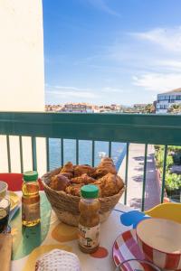 a basket of bread sitting on a table on a balcony at Escapade Marine - Vue Etang - Place de parking privé - Plage à 5 min in Le Barcarès