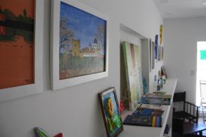 a row of paintings on a wall next to sidx sidx sidx at Agua De Coco in Villa Gesell