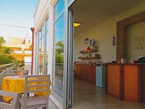 a patio with a table and a kitchen with sliding glass doors at B&B - TallyHo in Salve