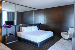 a bedroom with a large bed and a chair at Palms Place Hotel and Spa in Las Vegas