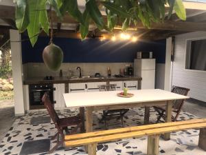 a kitchen with a table and chairs and a sink at Coco'Living - Gîtes de standing partagés in Gourbeyre