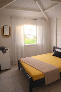 a bedroom with a bed and a window at Coco'Living - Gîtes de standing partagés in Gourbeyre