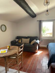 a living room with a couch and a table at MAS-Calou in Coustellet