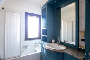 a bathroom with a sink and a tub and a mirror at Casa la Gabbianella in San Teodoro