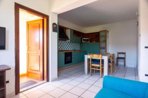 a living room with a blue couch and a table at Casa la Gabbianella in San Teodoro