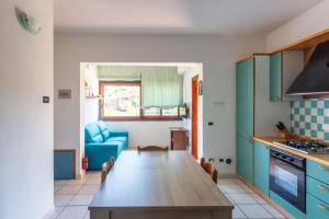a kitchen with a wooden table and a blue chair at Casa la Gabbianella in San Teodoro +18 photos