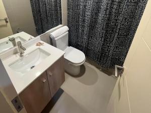 a bathroom with a sink and a toilet and a shower curtain at Laurel de oro in Chillán