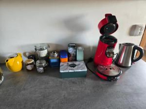 a kitchen counter with a coffee maker and other items at La P'tite Chaumiere in Domaize