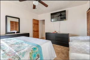 a bedroom with a bed and a dresser and a television at Oceanview Retreat in Bull Bay +3 photos