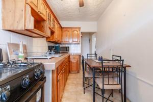 a kitchen with wooden cabinets and a table with chairs at Oceanview Retreat in Bull Bay