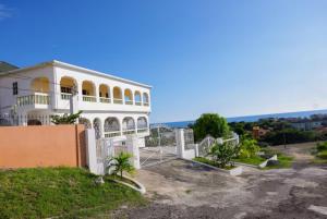 a large white building with a balcony and the ocean at Oceanview Retreat in Bull Bay