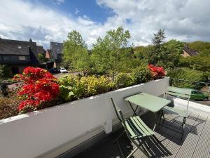 a balcony with two chairs and a table and flowers at Renovierte Doppelhaushälfte in bester Lage in Bottrop