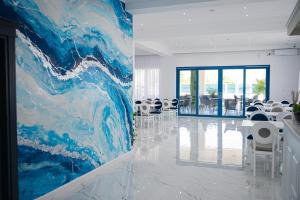 a large painting on the wall of a room with chairs at Pensiunea Paradisul Mării in Sulina