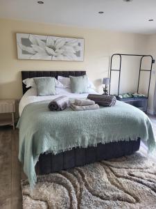 a bedroom with a large bed with a green blanket at The Old Barn in Hanbury +50 photos