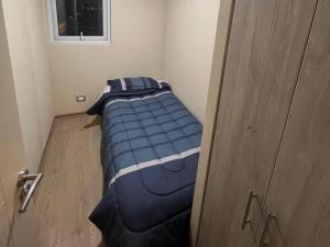 a bed in a small room next to a door at Laurel de oro in Chillán