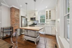 a kitchen with white cabinets and a table and chairs at Boston Escape Near T in Boston