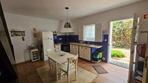 a kitchen with a table and a white refrigerator at Quinta das Candeias in Candelária
