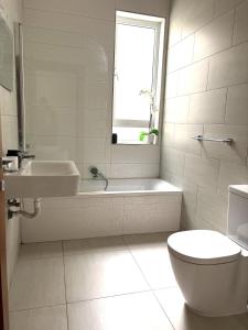 a bathroom with a tub and a sink and a toilet at Grand Residence 3-Bedroom Spacious Premium Central Apartment in Is-Swieqi